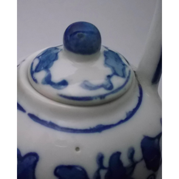 Close up of lid of porcelain teapot and small dot