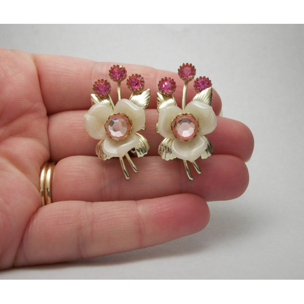Picture of hand holding vintage celluloid flower clip on earrings